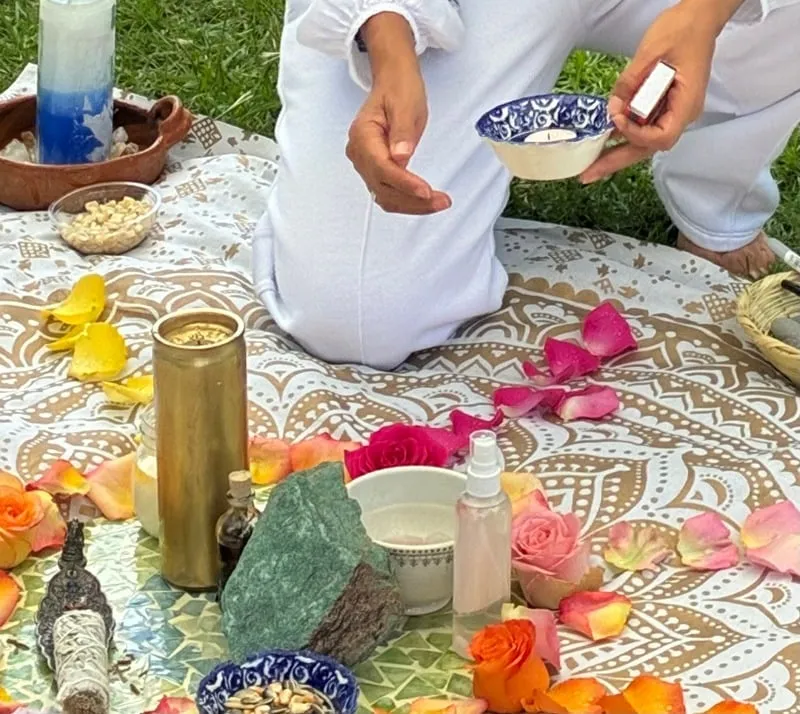 Altar de ceremonia con rosas, agua y cuarzos sobre un mandala