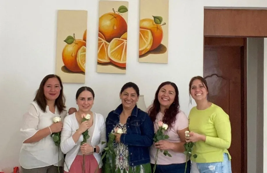 Grupo de participantes de un taller con rosas blancas