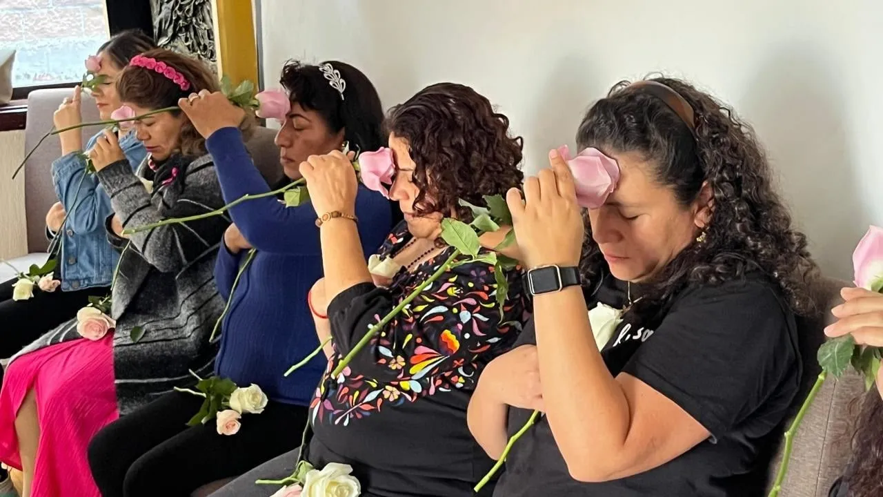 Participantes de un taller con rosas en la frente, en meditación
