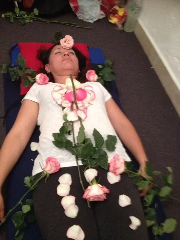 Sesión de Sanación con Rosas: rosas sobre el cuerpo de una persona recostada
