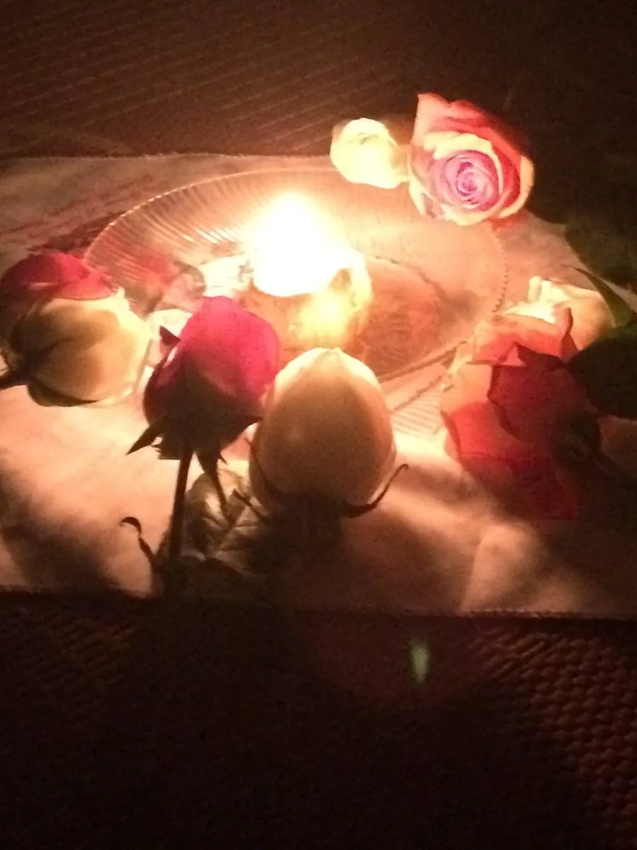 Roses arranged around a lit candle