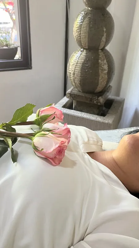 A pink rose resting on a person during a session
